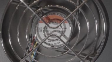 Valmiera, Letonya - 18 Kasım 2024 - Görünür bıçaklı, koruyucu ızgaralı ve üretici detaylı bir bilgisayar soğutma vantilatörünün yakın görüntüsü, donanım bileşenleri sergileniyor.