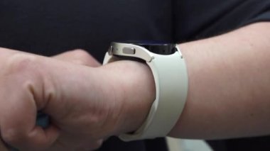 Valmiera, Letonya - 28 Kasım 2024 - Dokunmatik bir jest kullanarak, giyilebilir teknoloji ve işlevselliği vurgulayarak akıllı bir hareketle etkileşime giren bir insanın yakın çekimi.