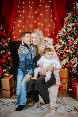 Bir anne oğluyla ve bebeğiyle oturur, Noel ağaçlarıyla çevrili neşeli bir anı paylaşır, neşeli ışıklar, ve sıcacık bir ortama sarılmış hediyeler..