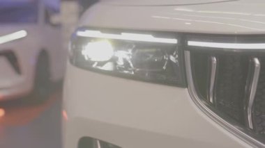 Riga, Letonya - 2 Aralık 2024 - Parlak LED aydınlatma, sergilenen parlak otomotiv estetiği ile modern bir araba far ve ön ızgara tasarımı.