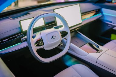 Riga, Latvia - December 2, 2024 - Dongfengs new car interior showcasing the sleek steering wheel with its logo, advanced digital displays, and futuristic purple lighting clipart