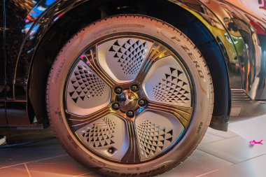 Riga, Letonya - 2 Aralık 2024 - Dongfeng araba tekerleğinin yakın çekimi Pirelli lastikli, modern otomotiv tasarımını yansıtan karmaşık bir fütüristik çember tasarımı sergiliyor