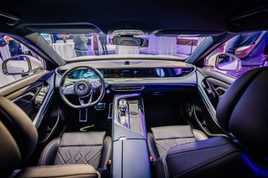 Riga, Letonya - 2 Aralık 2024 - Gösterişli bir Dongfeng aracının iç görünümü, gösterişli bir direksiyon, ileri gösterge paneli ve sunum sırasında premium deri koltuklar.