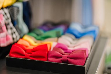 A vibrant display of bow ties in various colors neatly arranged in a box, showcasing a range of hues for formal and stylish occasions. clipart