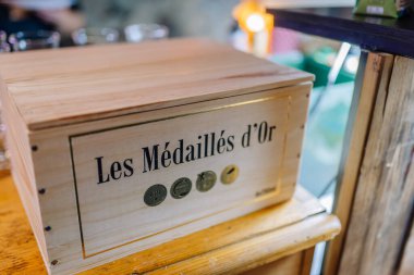 Valmiera, Letonya - 7 Aralık 2024 - Üzerinde Les Mdaills etiketli ahşap bir kutu altın detayları olan, ahşap bir yüzeye yerleştirilmiş, lüks ve işçiliği çağrıştıran
