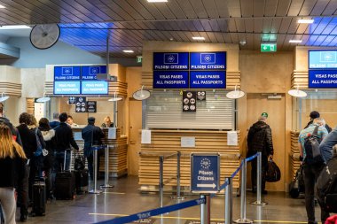 Letonya, Riga - 21 Şubat 2020 - AB vatandaşları ve tüm pasaportlar için sınır denetiminde kuyruk oluşturan yolcular, havaalanında belge işlemleri yapan memurlar.