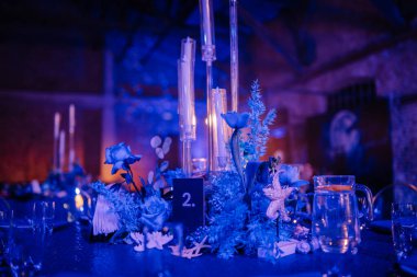 Mumlar, çiçekler ve deniz yıldızının süslediği mavi temalı masa dekoru sualtından esinlenilmiş zarif bir ortam yaratıyor..