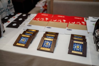 Belek, Türkiye - 27 Şubat 2020 - Masada mavi ve altın aksanlı ahşap plakalar, renkli klasörler ve profesyonel bir ortamda olay materyallerinin yanı sıra.
