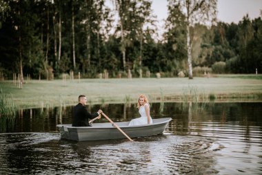 Valmiera, Letonya - 24 Ağustos 2024 - Sakin bir gölde, sakin bir gölde bir gelin ve damat, romantik ve sakin bir düğün anı yaratıyor..