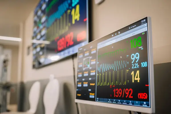 Valmiera, Letonya - 17 Ocak 2025 - ECG, kalp atışı ve kan basıncı gibi hayati belirtileri hastane ortamında gösteren tıbbi monitörlerin yakın çekimi.