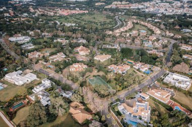 Sotogrande, İspanya - 26 Ocak 2025 - Zarif villaları, özel havuzları, manzaralı bahçeleri ve huzurlu bir banliyö atmosferi olan lüks bir yerleşim bölgesinin havadan görünüşü.