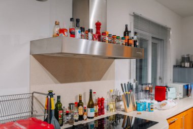 Malaga, İspanya - 24 Ocak 2025 - Baharat, bıçak ve temel yemek malzemeleriyle modern mutfak tezgahı. Bir çeşit kaput ve çeşitli baharatlar yemek pişirme kolaylığı için sergilenir.