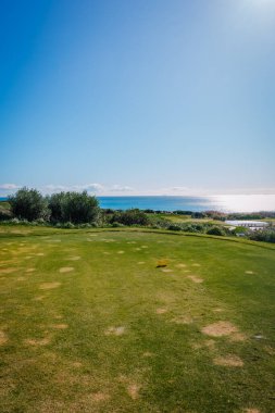 Endülüs, İspanya, 30 Ocak 2025 La Hacienda golf sahasının güneşli manzarası yemyeşil, ışıl ışıl okyanus suyu ve arka planda açık mavi bir gökyüzü..