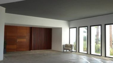 Endülüs, İspanya - 30 Ocak 2025 - Büyük cam pencereli modern iç mekan, ahşap bir kapı, tahta bir duvar paneli, bir sandalye ve boşluğu aydınlatan doğal ışık.