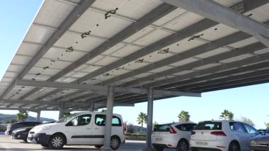 Endülüs, İspanya, 30 Ocak 2025 - Güneşli bir günde güneşli bir günde, etrafı palmiye ağaçları ve açık mavi gökyüzü ile çevrili, güneşle kaplı park yeri.