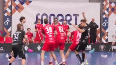 Valmiera, Letonya - 5 Şubat 2025 - Kırmızı ve siyah formalı stat oyuncuları arka planda antrenörler ve izleyicilerle bir maçta yarışıyor. Yoğun spor hareketi.