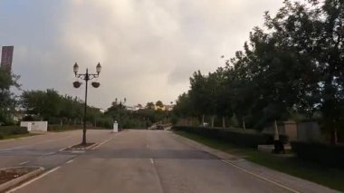 Endülüs, İspanya - 28 Şubat 2025 - İspanya 'da manzaralı bir yol, araba süren, lamba direkleri, yemyeşil, ve bulutlu bir gökyüzünün altında bir satış merkezi tabelası.