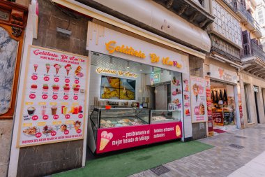 Endülüs, Malaga - 31 Ocak 2025 - Renkli tabelası olan dondurma dükkanı Gelateria Di Amore, çeşitli tatları gösteren açık bir tezgah ve el yapımı ikramlar içeren bir menü