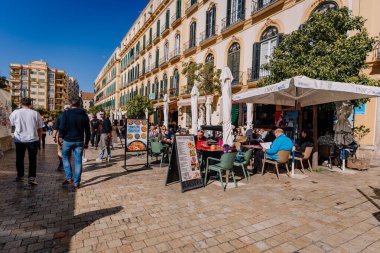 Endülüs, Malaga - 31 Ocak 2025 - Açık mavi gökyüzü altında yürüyen, açık kafeinli ve tarihi binaları olan canlı bir yaya sokağı