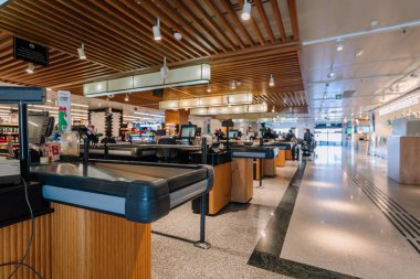 Endülüs, Malaga - 31 Ocak 2025 - Modern tasarım, ahşap aksanlı ve parlak ışıklandırmalı boş süpermarket çıkış yolları, temiz ve düzenli bir alışveriş ortamı yaratıyor.