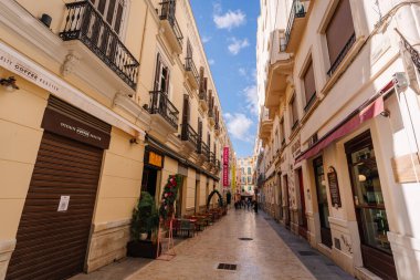 Endülüs, Malaga - 31 Ocak 2025 - Malaga 'da renkli vitrinleri, açık hava koltukları, geleneksel mimarisi ve açık mavi gökyüzü olan büyüleyici bir yaya sokağı.