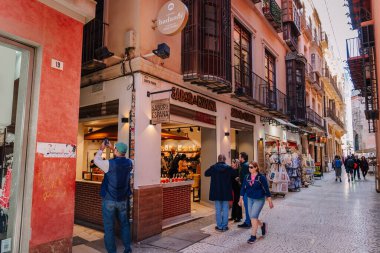 Endülüs, Malaga - 31 Ocak 2025 - Sabor 'daki Espana mağazasından alışveriş yapan insanların bulunduğu canlı bir cadde, geleneksel İspanyol mimarisi ve hediyelik eşya dükkanlarıyla çevrili..