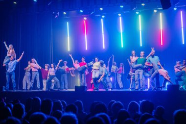 Valmiera, Letonya - 8 Şubat 2025 - 90 'ların partisi. Bir grup enerjik dansçı, neon ışıklarının altında, dinamik kaldırma ve hareketlerle seyirciyi kendine çeken canlı bir gösteri sergiliyor..