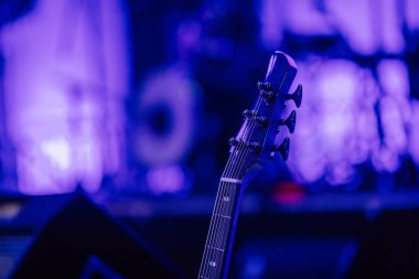 Valmiera, Letonya - 29 Aralık 2024 - Yamaha etkinliği. Sahnede, arka planda bulanık mavi ve mor ışıklar olan bir gitar başlığının yakın çekimi dramatik ve müzikal bir atmosfer yaratıyor..