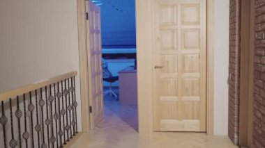 Pijamalı genç bir kadın sabahın erken saatlerinde yatak odasından banyoya çıplak ayakla yürür..