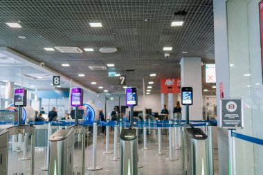 Riga, Letonya - 22 Şubat 2025 - Otomatik havaalanı güvenlik kapıları ve biyometrik yüz tanıma tarayıcıları. Arka planda yolcuların ve personelin bulunduğu modern otomatik kontrol alanı..
