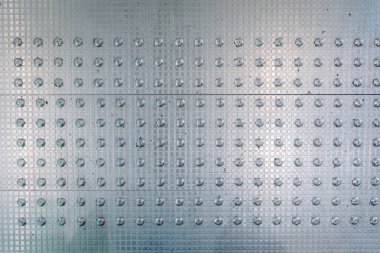 İstanbul, Türkiye - 22 Şubat 2025 - Halka açık alanlarda rehberlik ve güvenlik sağlayan, görme engelli bireyler için tasarlanmış yükseltilmiş yükseltilmiş çivili metalik bir asfalt yüzeyi.