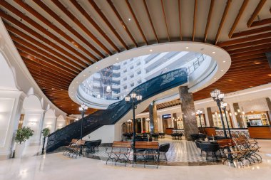 Serik, Türkiye - 24 Şubat 2025 - Büyük merdiveni, modern ışıklandırması, şık oturma alanları ve sofistike mimari tasarımı olan zarif bir otel iç mimarisi.