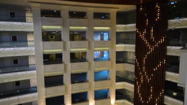 Çok katlı lüks bir otel, zarif balkonlar ve dekoratif ışıklandırma. Modern mimari sıcak ortam aydınlatmasına sahiptir..
