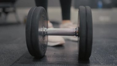 Valmiera, Letonya - 4 Şubat 2025 - Spor salonunda ağır bir dambılı kavrayan, halter egzersizi için hazırlanan, güç ve kararlılığı vurgulayan bir ele yakın çekim.