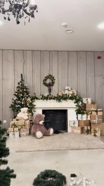 Süslü bir şöminesi, paketlenmiş hediyeleri, küçük bir ağacı, çelenkleri ve bayramlık ayıları olan rahat bir Noel sahnesi..