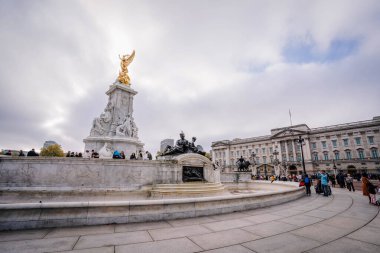 Londra, Birleşik Krallık - 23 Kasım 2022 - Londra 'daki Victoria Anıtı ve Buckingham Sarayı' nda turistler bulutlu bir günde tarihi bir dönüm noktasını keşfediyorlar..