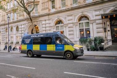 Londra, Birleşik Krallık - 12 Kasım 2022 - Bir Metropolitan Polis Bölgesi Destek Grubu minibüsü Londra 'da bir şehir caddesinden geçerek, şenlikli süslemeleri olan tarihi binaların önünden geçti.