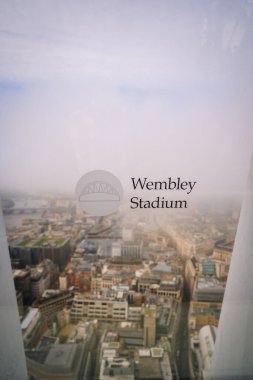 Londra, İngiltere - 12 Kasım 2022 - Wembley Stadyumu metin ve logosuna sahip cam pencere, Londra 'nın binaları, caddeleri ve Thames Nehri' ne bakan sisli hava manzarası