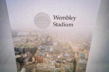 Londra, Birleşik Krallık - 12 Kasım 2022 - Wembley Stadyumu metin ve logosuna sahip cam pencere, Londra 'nın sisli şehir manzarasına bakan arka planda binalar ve caddeler
