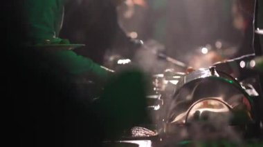 Valmiera, Letonya - 29 Kasım 2024 - İnsanlar sıcak ortam aydınlatması altında, et ve sebzeler de dahil olmak üzere çeşitli yemeklerle dumanı tüten bir açık büfe masasında kendilerine yemek servis ediyorlar.