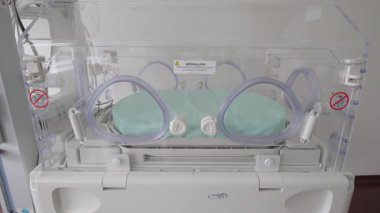 Valmiera, Letonya - 24 Mart 2025 - Bir hastane ortamında erken veya hasta yeni doğanlar için tasarlanmış yumuşak mavi yataklı modern bir yenidoğan inkübatörünün yakın çekimi.