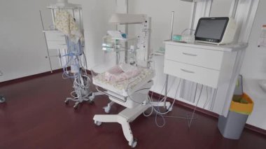 Valmiera, Letonya - 24 Mart 2025 - Temiz bir klinik hastane ortamında bebek için ısıtma yatağı, izleme ekipmanları, vantilatör ve tıbbi cihazları olan yenidoğan bakım odası.