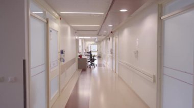 Valmiera, Letonya - 24 Mart 2025 - Beyaz duvarları, tıbbi gereçleri ve hemşire istasyonunda boş sandalyeleri olan parlak ve temiz hastane koridoru,.