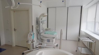 Valmiera, Letonya - 24 Mart 2025 - Yeni doğan bakım cihazlarıyla donatılmış modern hastane doğum odası, bebek ısıtıcı ve vakum makinesi, temiz bir klinik ortamında.