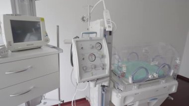Valmiera, Letonya - 24 Mart 2025 - Hastanenin yenidoğan odası boş bir kuluçka makinesi, izleme ekranı ve prematüre bebek bakımı ve gözlem için kullanılan yaşam destek cihazıyla.