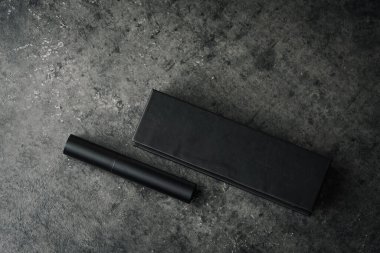 Siyah mat kalem ve dikdörtgen kutu koyu dokulu taş yüzeyde, cesur, profesyonel ve endüstriyel temalı ürün görüntüsü oluşturur..
