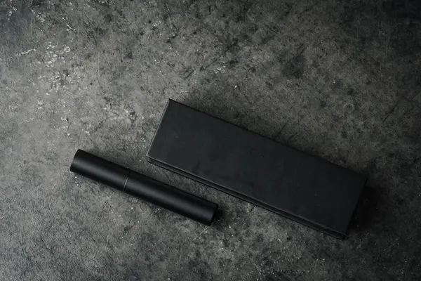 Siyah mat kalem ve dikdörtgen kutu koyu dokulu taş yüzeyde, cesur, profesyonel ve endüstriyel temalı ürün görüntüsü oluşturur..
