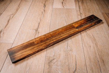 Yanmış ahşap döşeme, koyu renk kaplama, hafif ahşap zemine yerleştirilmiş. Yakından görüntü dokusu ve kontrastı. Yanmış ahşap tarzı. Tasarım kullanımı için uygun.