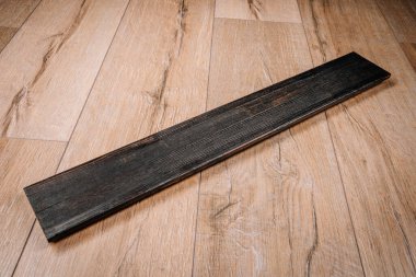 Yanmış ahşap döşeme, koyu renk kaplama, hafif ahşap zemine yerleştirilmiş. Yakından görüntü dokusu ve kontrastı. Yanmış ahşap tarzı. Tasarım kullanımı için uygun.