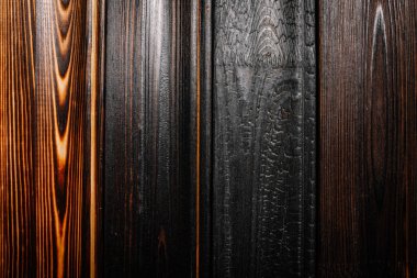 Doğal tahıl ve işçiliği vurgulayarak, kömürleşmeden cilalanmaya kadar benzersiz doku ve tonlarını gösteren çeşitli yanık ahşap tahtaların yakın çekimi.